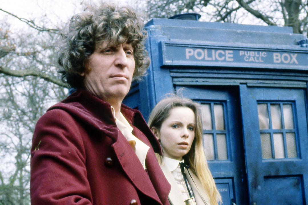 Tom Baker as Doctor Who standing in front of the Tardis.