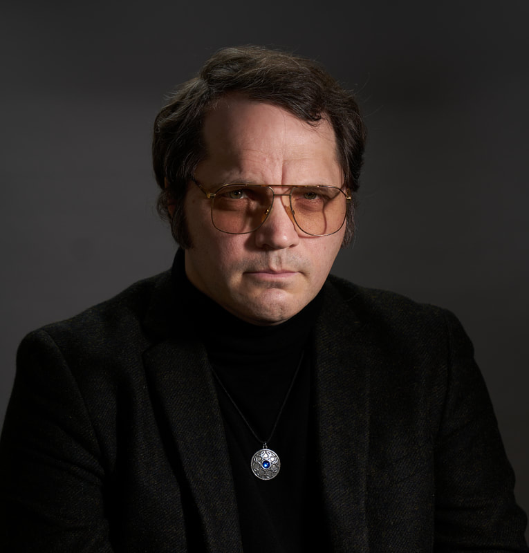 Fictional horror writer Garth Marenghi looking serious and wearing a black jacket.