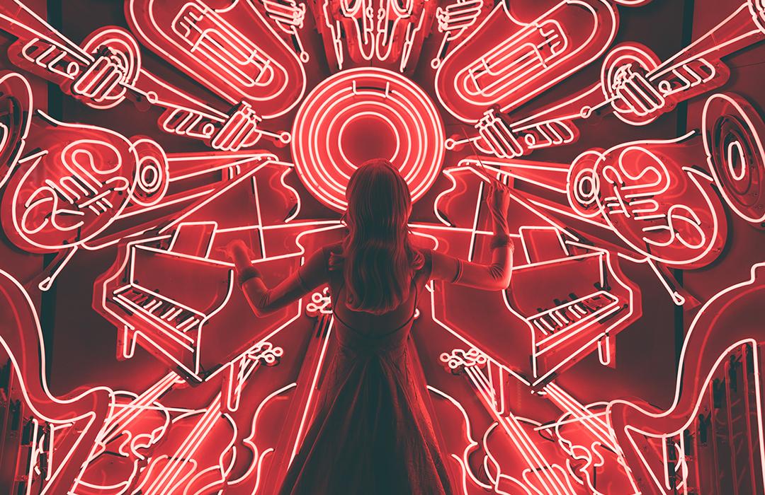 A drawing of a woman surrounded by drawings of various instruments drawn in white light.