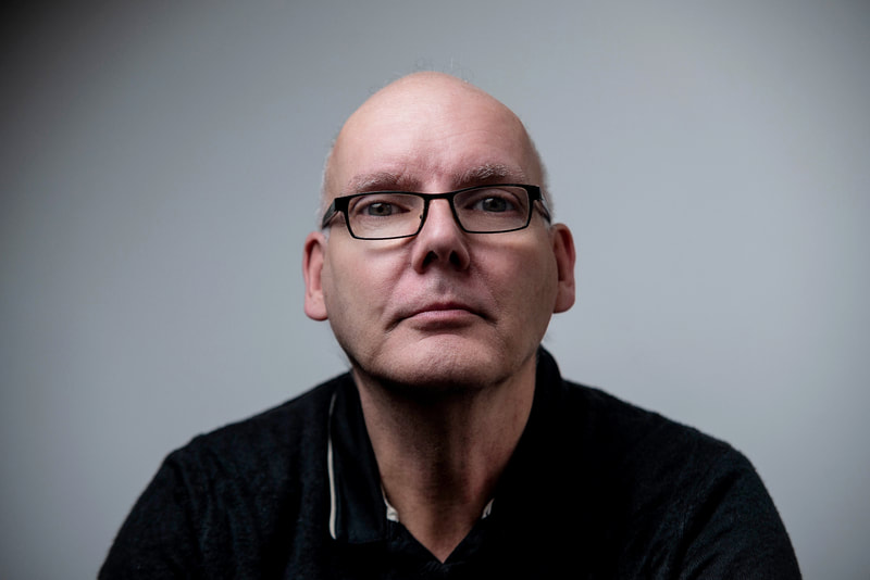 A headshot of Multiview Media CEO Ray Meadham. He's bald and wearing black framed glasses.